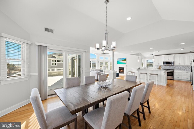 dining room with a wealth of natural light, visible vents, and lofted ceiling