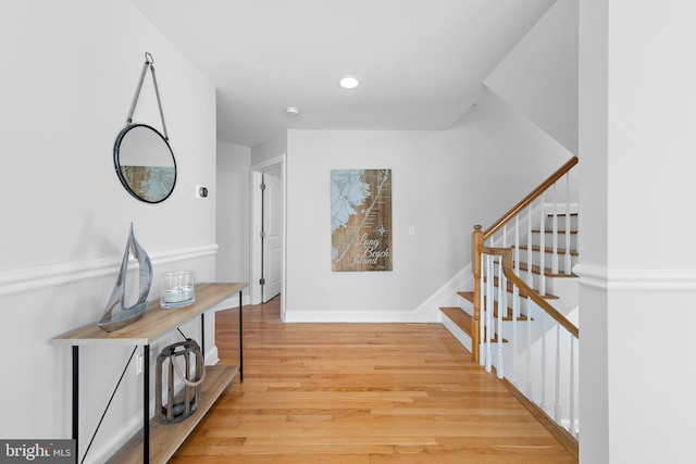 hallway featuring recessed lighting, stairs, baseboards, and wood finished floors