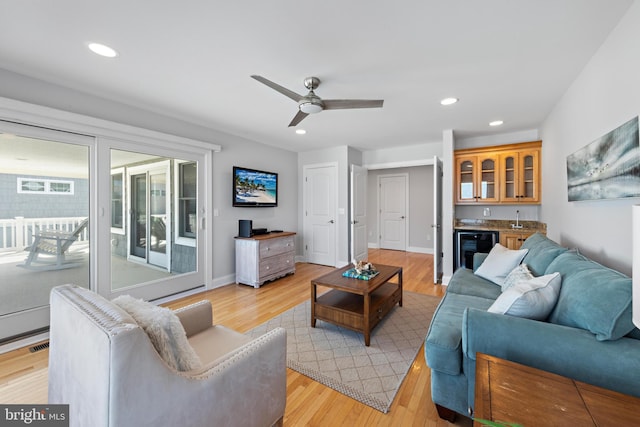 living area with recessed lighting, indoor wet bar, wine cooler, and light wood finished floors