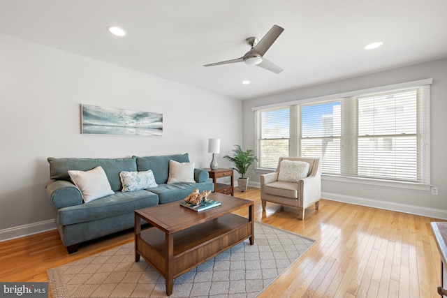 living room featuring recessed lighting, baseboards, and light wood-type flooring