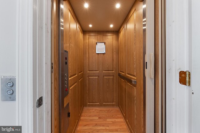 interior details with elevator, wood finished floors, and recessed lighting