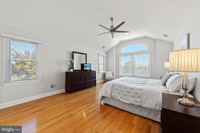 bedroom with visible vents, light wood-type flooring, and vaulted ceiling