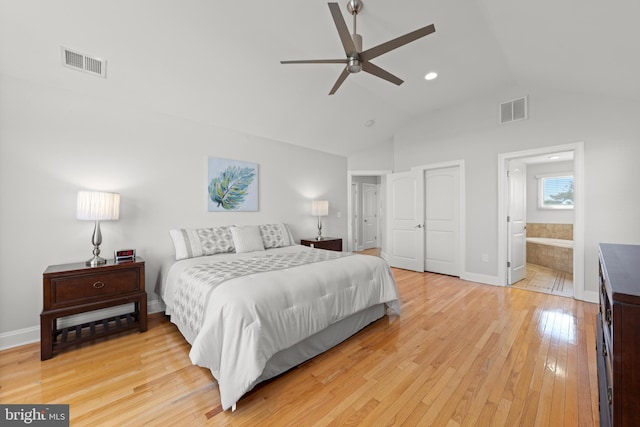 bedroom with visible vents, lofted ceiling, ensuite bath, and light wood finished floors