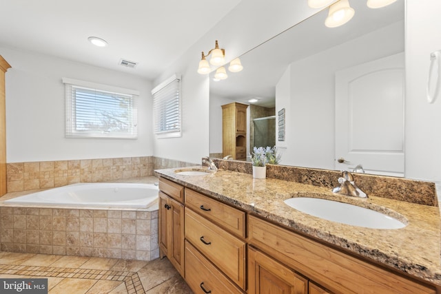 bathroom featuring a shower stall, a garden tub, double vanity, and a sink