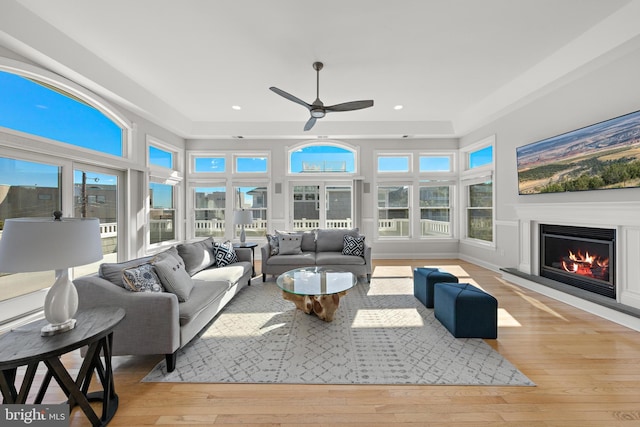 sunroom featuring ceiling fan and a lit fireplace