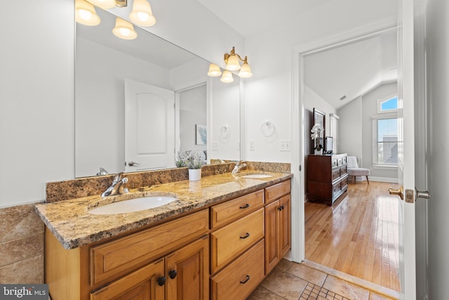 bathroom with double vanity, tile patterned flooring, lofted ceiling, and a sink