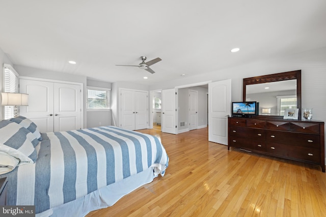 bedroom featuring recessed lighting, light wood-style flooring, two closets, and ceiling fan