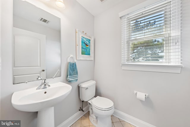 half bathroom featuring tile patterned floors, visible vents, toilet, and baseboards