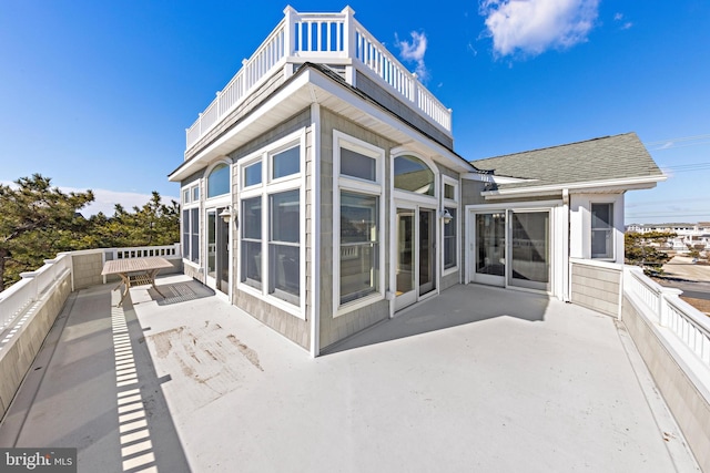 back of property with a patio, a balcony, and a shingled roof