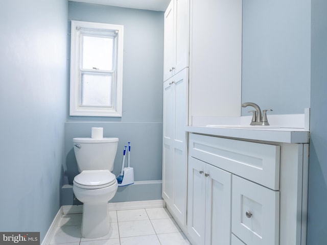 bathroom featuring baseboards, toilet, vanity, and tile patterned flooring