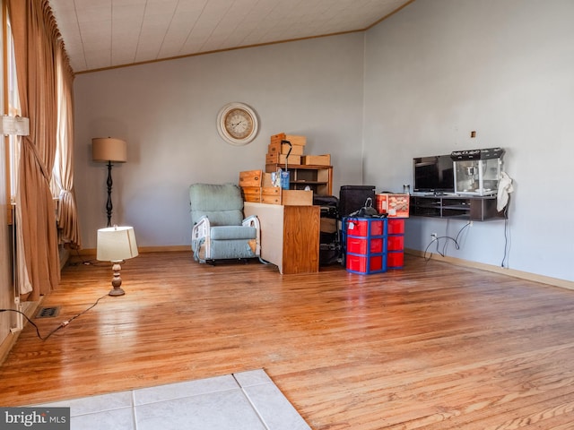 interior space with visible vents, baseboards, wood finished floors, and crown molding