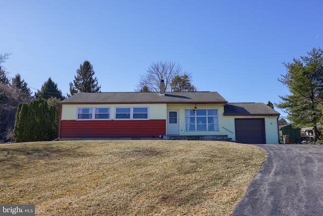 ranch-style home with aphalt driveway, a front lawn, and a garage