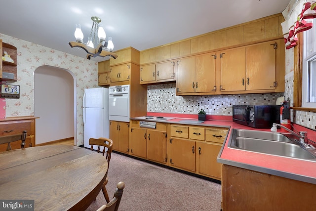 kitchen with white appliances, wallpapered walls, an inviting chandelier, arched walkways, and a sink