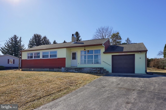 ranch-style home with aphalt driveway, a front lawn, a chimney, and a garage