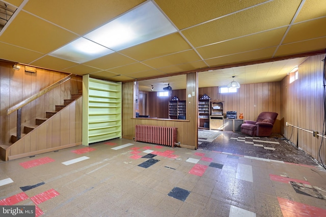 basement with tile patterned floors, a drop ceiling, stairs, and radiator heating unit