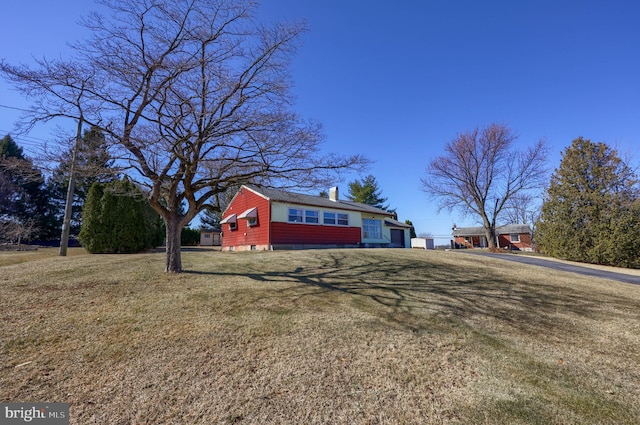 view of property exterior with a yard and a chimney