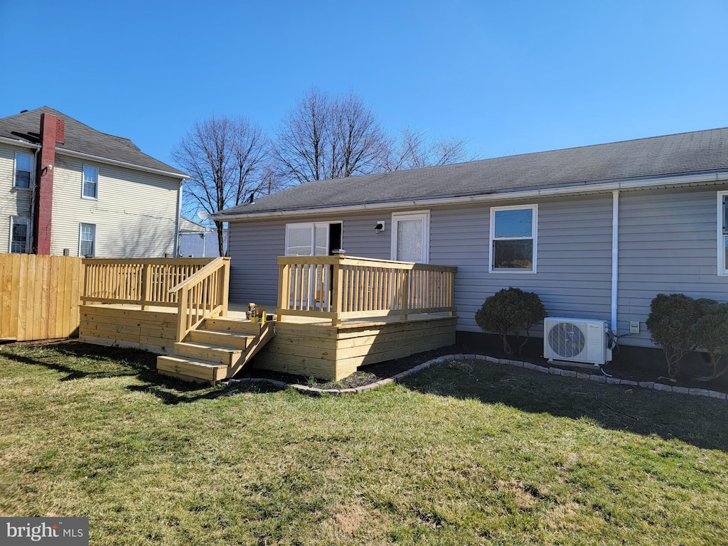 back of house with ac unit, a wooden deck, and a lawn