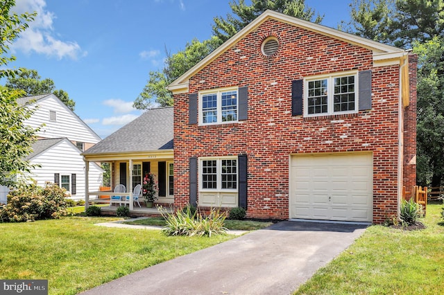 view of front of house featuring a front lawn, brick siding, covered porch, and driveway