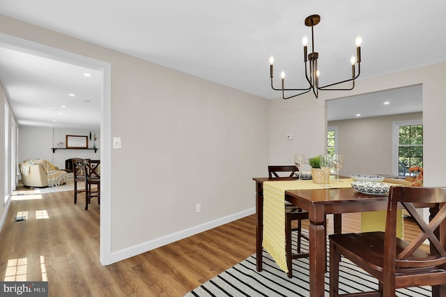 dining area featuring light wood finished floors, a chandelier, recessed lighting, and baseboards