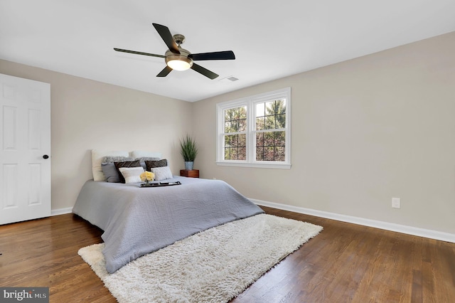 bedroom featuring ceiling fan, baseboards, and wood finished floors