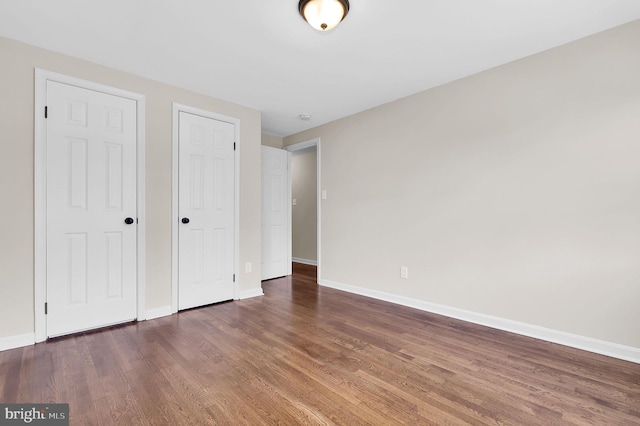 unfurnished bedroom with baseboards and wood finished floors