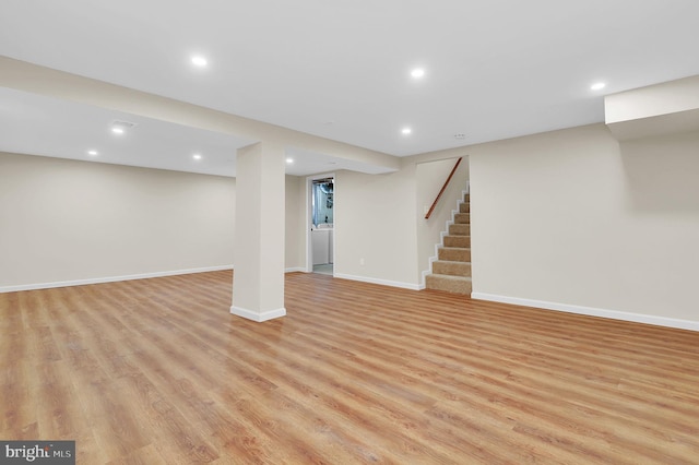 finished basement with recessed lighting, baseboards, stairs, and light wood finished floors