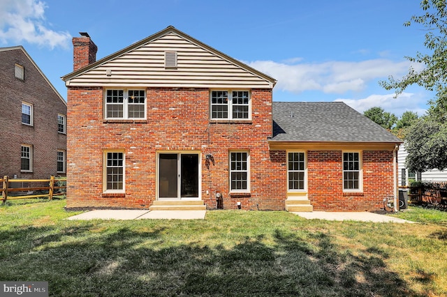 back of house with brick siding, a lawn, and entry steps