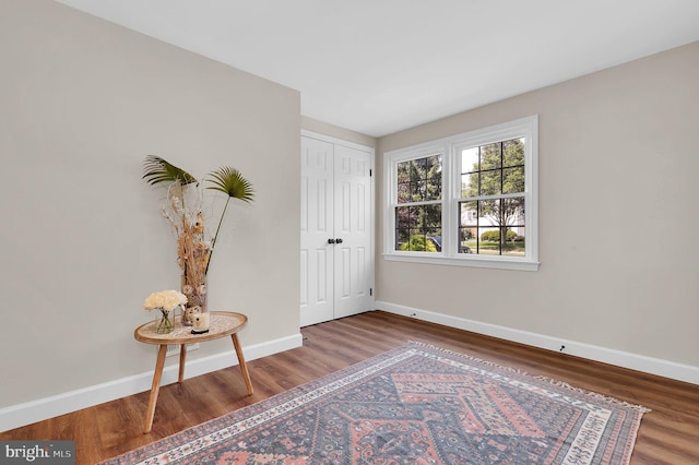 unfurnished bedroom with a closet, baseboards, and wood finished floors