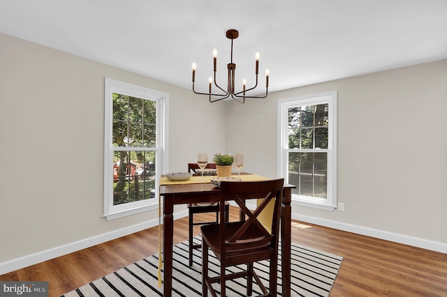 dining area with a chandelier, baseboards, and wood finished floors