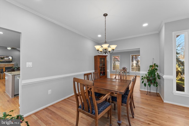 dining area featuring light wood-style flooring, baseboards, and ornamental molding