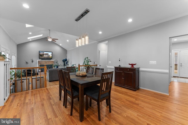 dining room featuring a fireplace, light wood-style floors, and ornamental molding