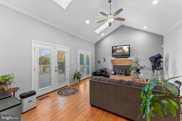 living area with wood finished floors, visible vents, a skylight, french doors, and crown molding