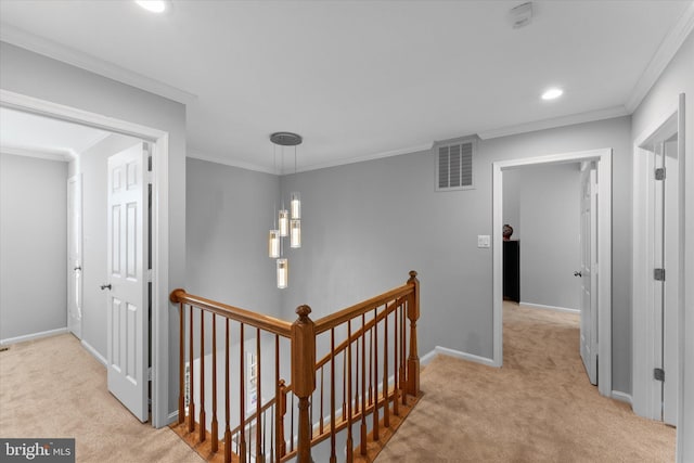 hallway with crown molding, carpet flooring, an upstairs landing, and visible vents