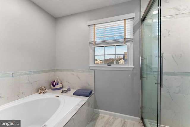 bathroom with baseboards, marble finish floor, a bath, and a shower stall