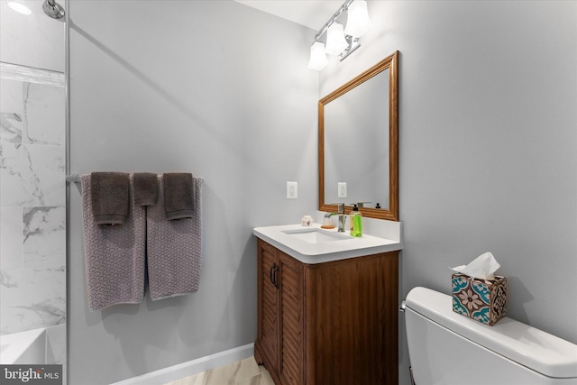 bathroom featuring vanity, toilet, and baseboards