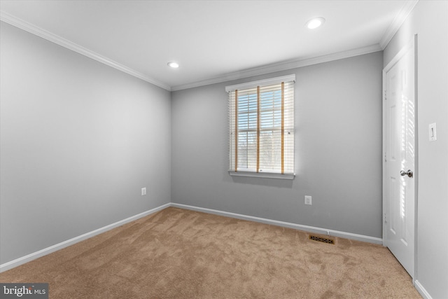 carpeted spare room featuring baseboards, visible vents, and ornamental molding