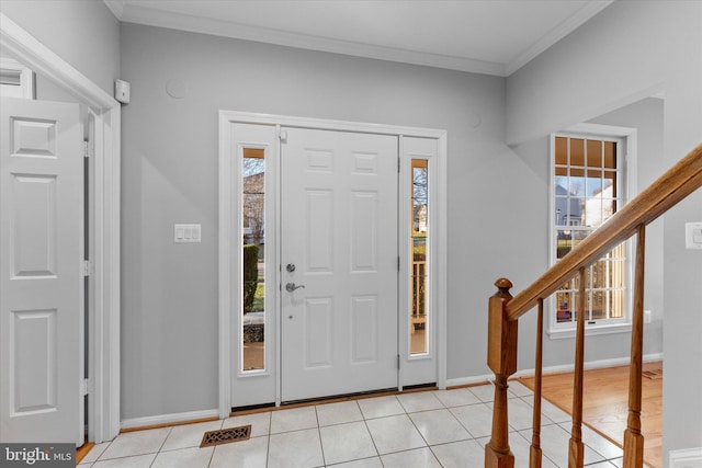 entryway featuring stairs, crown molding, light tile patterned flooring, and baseboards