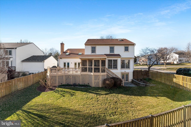 rear view of property with a deck, a fenced backyard, french doors, a yard, and a sunroom