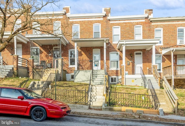 townhome / multi-family property featuring brick siding and a fenced front yard