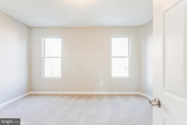 carpeted empty room featuring baseboards