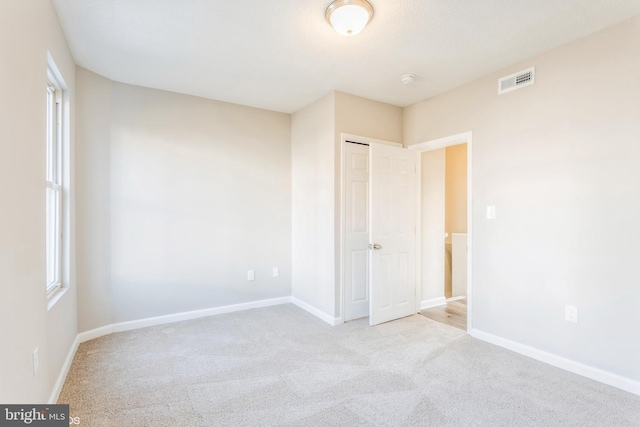 unfurnished bedroom with a closet, visible vents, baseboards, and carpet floors