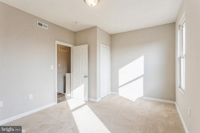 unfurnished bedroom featuring visible vents, baseboards, and carpet