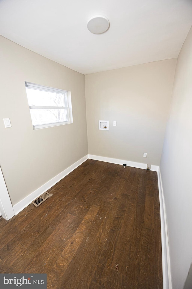 empty room with visible vents, baseboards, and wood finished floors