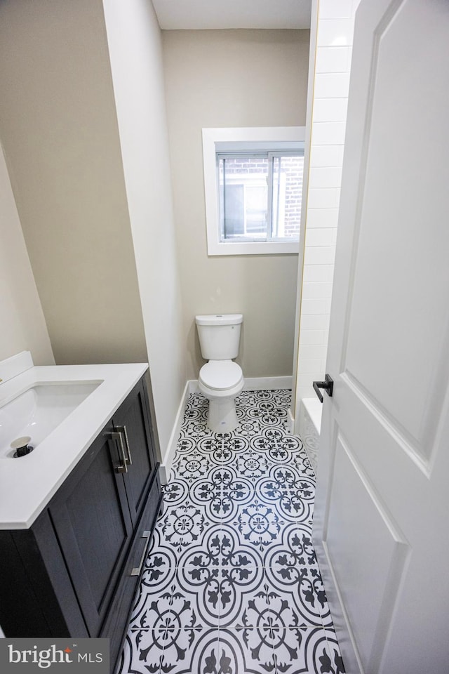 bathroom featuring baseboards, toilet, vanity, and tile patterned flooring