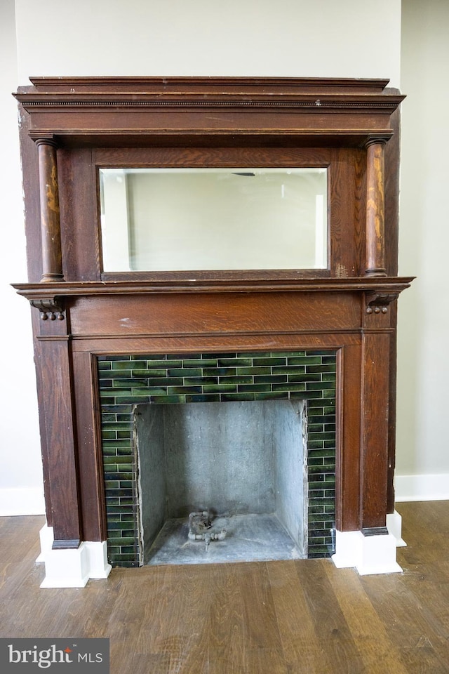 room details with a tiled fireplace, wood finished floors, and baseboards