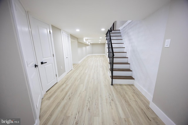 finished below grade area with stairs, recessed lighting, baseboards, and light wood finished floors