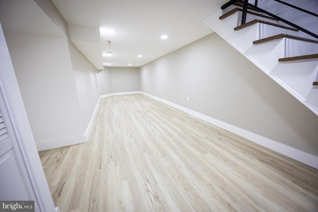 finished below grade area with recessed lighting, stairs, baseboards, and wood finished floors