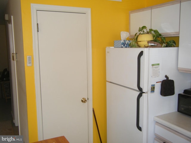 kitchen with light countertops and freestanding refrigerator