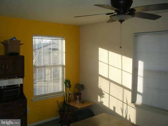 unfurnished office featuring baseboards and a ceiling fan