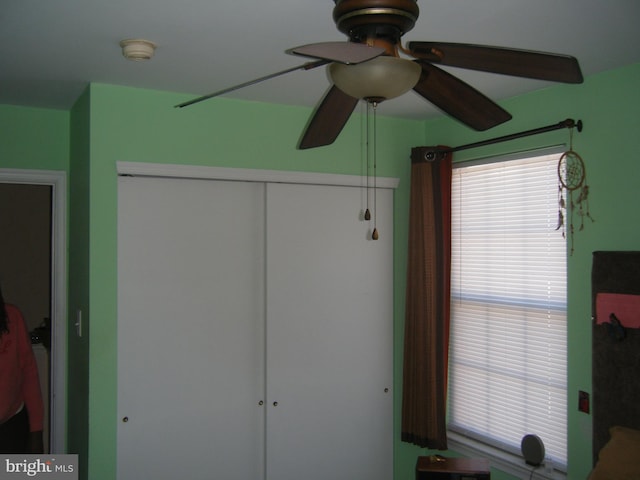 unfurnished bedroom with a ceiling fan and a closet